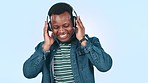 Dance, headphones and happy black man in studio for streaming song, radio and audio. Happy, dancing and person listening to track, music and excited with energy, happiness and fun on blue background
