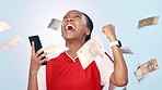 Sports woman, money rain and phone in studio, fist celebration and cheers for goals by blue background. African athlete girl, smartphone and cash in air with fintech, gambling or investment profit