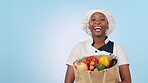 Groceries, food and black woman chef smile for cooking vegetables isolated in a studio blue background. Shopping, happy and professional ready to prepare meal in mockup space as restaurant owner