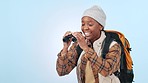 Excited, hiking and black woman with travel, binocular and surprise on a blue studio background. African person, happy model and traveller with happiness, bird watching and discovery with backpacking