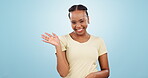 Face, woman and wave to you in studio for greeting, communication and emoji on blue background. Portrait, happy young african model and hand gesture for attention to sign language, hello and welcome 