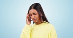 Stress, headache and woman with anxiety in studio worry, fear or burnout on blue background. Vertigo, face and Indian lady model with temple massage for migraine, pain or brain fog, mistake or crisis
