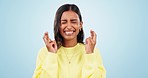 Wish, hope and fingers crossed with woman with good luck sign for success, winner and faith. Studio, blue background and female person with emoji, excited and optimism hand gesture with smile