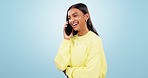 Phone call, speaking or happy Indian woman in studio on blue background for communication or chat. Mobile, joke or girl listening in conversation or talking about good news or feedback for networking