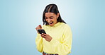Winner, surprise or woman excited by with phone notification in studio for online bonus or competition prize. Sale, wow or happy girl on blue background for mobile app promotion, winning or good news