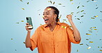 Smartphone, excited with black woman and confetti shower in studio, celebration and social media giveaway on blue background. Happiness, cheers and winning with online competition, dancing for reward