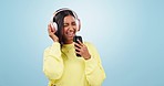 Music, phone or Indian woman in studio singing a song or radio audio on subscription in headphones. Relax, dance or happy girl streaming on an online mobile app isolated on a blue background for joy 