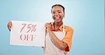 Happy black woman, billboard sign and discount price in advertising against a blue studio background. Portrait of excited African female person or waitress with poster for deal, sale or promotion