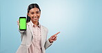 Business woman, phone green screen and pointing to marketing space, website information or opportunity in studio. Face of professional person on mobile app and mockup presentation on blue background