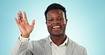 Face, wave and video call with a business black man talking on a blue background in studio for a tutorial. Portrait, smile and presentation with a young employee speaking during a webinar workshop