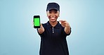 Happy black woman, phone and pointing to green screen for delivery app against a blue studio background. Portrait of African female person or employee showing mobile smartphone display or mockup