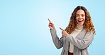 Pointing, excited and business woman in studio with success, happy and announcement. Professional, mockup and portrait of person on blue background with hand gesture for news, promotion and emoji