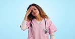 Headache, doctor and woman in studio with medical burnout, stress and tired of healthcare challenge on blue background. Frustrated, depressed and sick nurse with fatigue, brain fog or risk of mistake