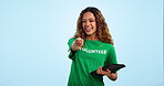 Woman volunteering, tablet and pointing at you to sign up online for charity and help on blue background. Community service, donation on nonprofit site and choice, registration and activism in studio