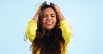 Headache, burnout and woman with stress, crying and depression on a blue studio background. Person, girl and model with tears, migraine and anxiety with mental health, sad and tired with expression