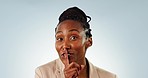 Face, smile and secret with a black woman silent about gossip on a blue background in studio. Portrait, mystery and finger on lips with a happy young person closeup to gesture a whisper emoji