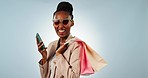 Happy black woman, phone and shopping bag for discount, sale or ecommerce against a studio background. Portrait of African female person or shopper smile with mobile smartphone for online promotion