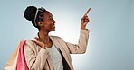 Black woman, shopping bags and pointing to list in advertising, sale or discount against a studio background. Portrait of happy African female person or shopper show options, deal or promo on mockup