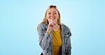 Happy woman, whisper and emoji for secret, gossip or confidential information on blue background in studio. Girl, smile and finger on lips or body language for privacy, shush and quiet voice