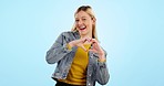 Heart, hands and face of woman dance in studio for kindness, care and charity donation on blue background. Happy portrait, model and freedom for love, hope and thanks for support, emoji sign or peace