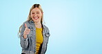 Thumbs up, pointing and woman with hands to choice, decision or presentation on blue background in studio. Happy, smile and girl with success, agreement and promotion of information in mockup space