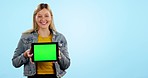 Woman, tablet and space with green screen in studio, promotion or brand review for app by blue background. Girl, student and face with digital touchscreen, mockup or happy for logo, sign and feedback