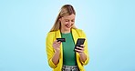 Phone, credit card and happy woman in studio with budget, investment or loan payment on blue background. Smartphone, app and excited female customer with online shopping, sign up or ecommerce deal 