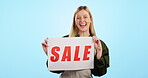 Woman, sale sign and studio blue background with smile for retail shopping, fashion or customer. Female, advertising  promo discount product and smile as mockup portrait, announcement or mall signage