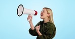 Megaphone, speech and happy woman shouting in studio for info, broadcast or news on blue background. Speaker, noise and excited female model with bullhorn for announcement of sale, deal or promotion
