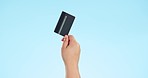 Credit card, payment and hand of person in studio for budget, savings or investment growth on blue background. Bank, finance and model show ecommerce, loan or service, opportunity or shopping offer