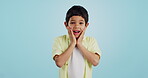 Smile, kid and hands on face for surprise in studio isolated on a blue background mockup space. Portrait, wow and happy child shocked at good news, promo announcement and excited facial expression