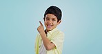Boy, smile and pointing with excitement in studio on blue background in mockup for opportunity, deal or alert. Youth, kid and happy with offer, discount or announcement on social media for consumers