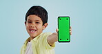 Kid, face or phone green screen in studio on social media for ecommerce, tech or download app logo. Blue background, space or happy child with notification for online marketing, mockup or advertising