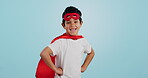 Happy, superhero or face of child with smile to fight in fantasy, dream or cosplay costume in studio. Boy power, brave or strong kid ready to protect freedom or justice with a mask on blue background