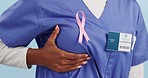 Closeup, hand and breast cancer with nurse, ribbon and support with information, hospital or healthcare. Awareness, zoom or medical professional with insurance cover, chest or disease with solidarity