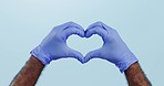 Closeup, hands and gloves with healthcare, heart and thank you on a blue studio background. Person, doctor and model with medical equipment, symbol for love and kindness with motivation and trust