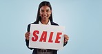 Sale sign, business woman and face excited from shopping deal, promotion and poster in studio. Happy, portrait and smile with discount announcement promo on paper for advertising with blue background