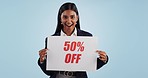 Discount price sign, woman and face excited from shopping deal, promotion and poster in studio. Happy, portrait and smile with sale announcement promo on paper for advertising with blue background