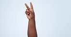 Two, hand and peace sign in studio with freedom, counting or emoji gesture with number. Count, finger and arm of a person with greeting, vote and v letter with blue background and happy icon