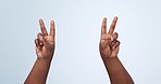 Two, hands and peace sign in studio with freedom, counting or emoji gesture with number. Count, finger and arms of a person with greeting, vote and v letter with blue background and happy icon