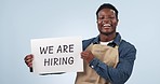 Happy black man, billboard and hiring for advertising job or opportunity against a studio background. Portrait of African male person or employee smile with poster or sign for recruiting on mockup