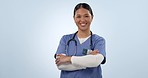 Woman, face and nurse smile in studio with arms crossed for healthcare services, surgery and consulting on blue background. Portrait, happy asian surgeon and professional medical doctor from Taiwan 