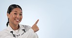 Doctor face, happy asian woman and pointing at healthcare commercial, hospital medicine promo or clinic studio notification. Medical portrait, mockup space and nurse presentation on blue background