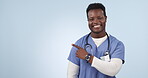 Nurse, advertising and black man pointing to space in studio isolated on a blue background. Portrait, hand and medical worker marketing healthcare, wellness promotion and smile for commercial mockup