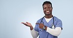 Nurse, advertising and black man pointing to palm in studio isolated on blue background. Portrait, hand and medical worker marketing healthcare, promotion offer and smile for commercial mockup space