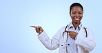 Pointing, happy and face of woman doctor in studio with mockup for advertising or marketing. Smile, mock up and portrait of African female healthcare worker with show hand gesture by blue background.