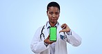 Phone, green screen and woman doctor with thumbs down in a studio for disapproval, unhappy or bad gesture. Tracking markers, mockup and African healthcare worker with cellphone by blue background.