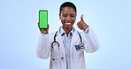 Phone, green screen and woman doctor with thumbs up in studio for approval, happy or agreement gesture. Tracking markers, mockup and African female healthcare worker with cellphone by blue background