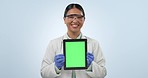 Asian woman, tablet and scientist with green screen in advertising against a studio background. Portrait of happy female person medical professional smile showing technology display, app or mockup