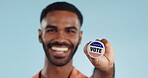 Vote pin, man and face with badge for politics, government and voting register for election. Studio, blue background and voter choice with administration decision with a smile and happy from support